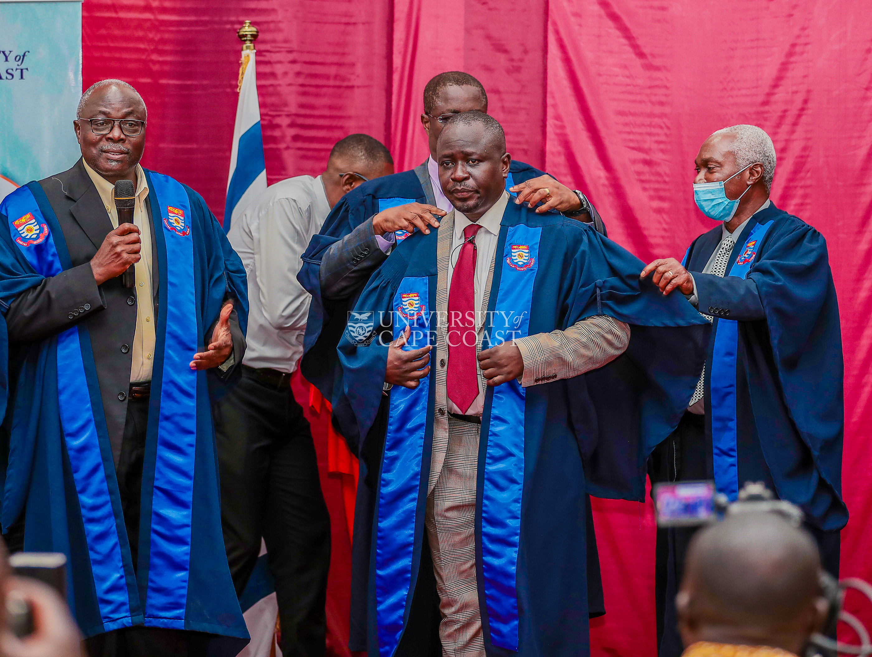 Prof. Annim being robed by some members of the College of Professors, UCC