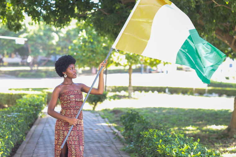 Ivorian student hoisting the flag of her country