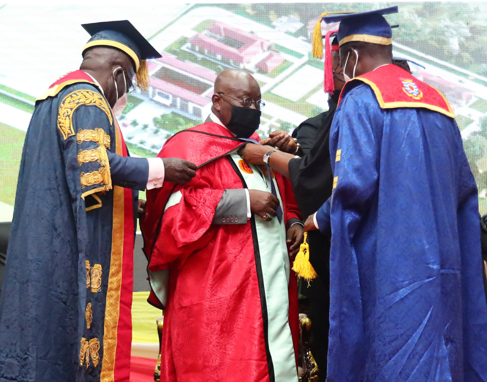 H. E. Nana Addo Dankwa Akufo-Addo, the President of the Republic being robed as Honorary Doctor by the Chancellor and Vice-Chancellor of the University of Cape Coast in 2021. Behind him is projected the building plan of 5, 500 student accommodation facili H. E. Nana Addo Dankwa Akufo-Addo, the President of the Republic being robed as Honorary Doctor by the Chancellor and Vice-Chancellor of the University of Cape Coast in 2021. Behind him is projected the building plan of 5, 500 student accommodation facili