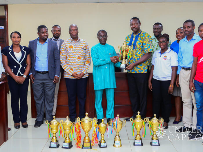 A delegation led by a member of the University of Cape Coast (UCC) Sports and Recreation Committee, Dr. Clement Apaak presenting the trophies to the VIce-Chancellor, Prof. Johnson Nyarko Boampong.