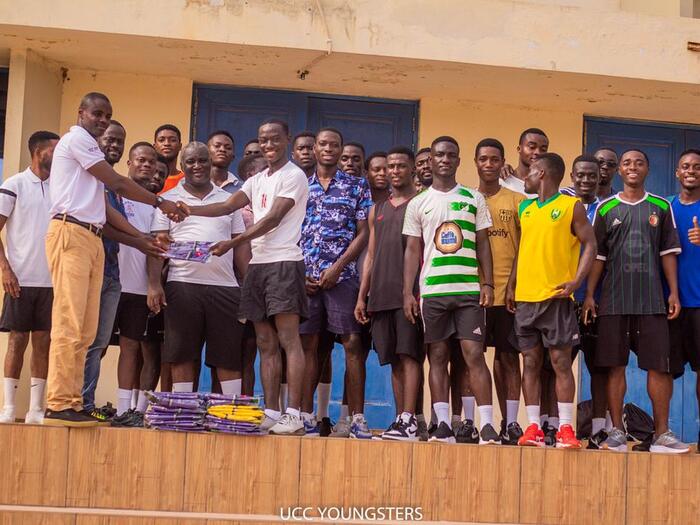 The SRC President presenting the t-shirts to coaches of the team